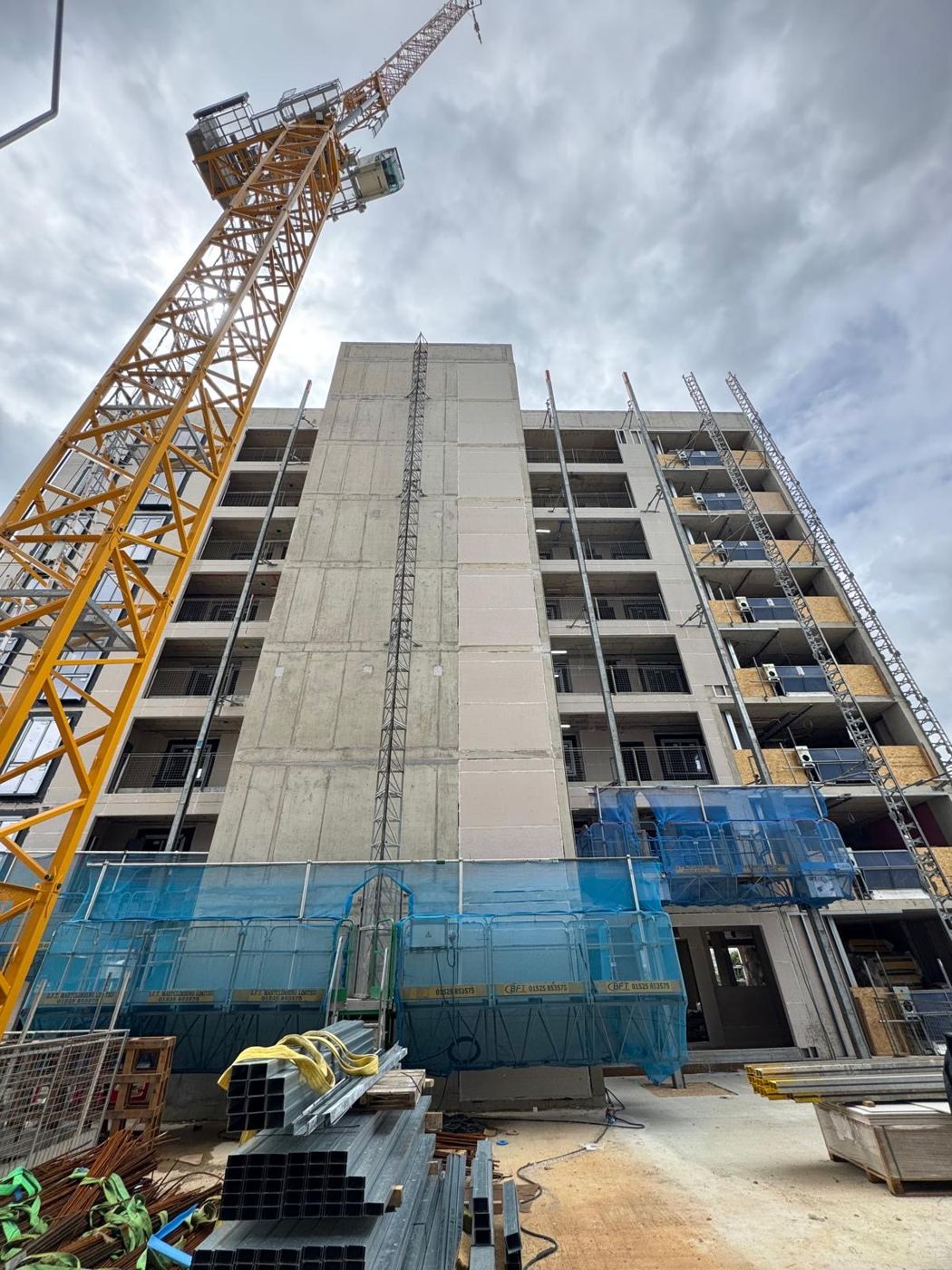 Concrete-framed residential block under construction with tower crane