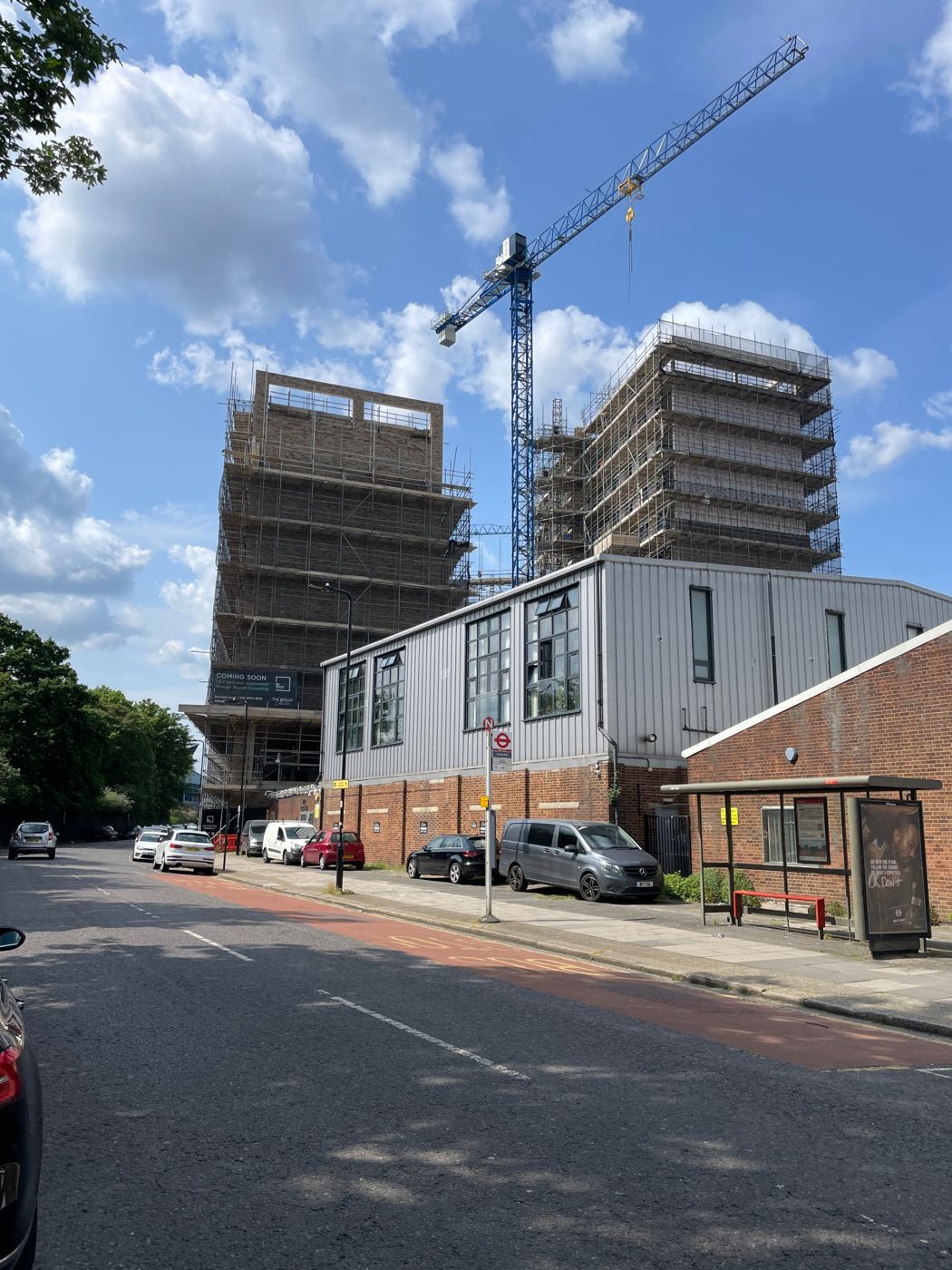 Two scaffolded residential towers with a tower crane